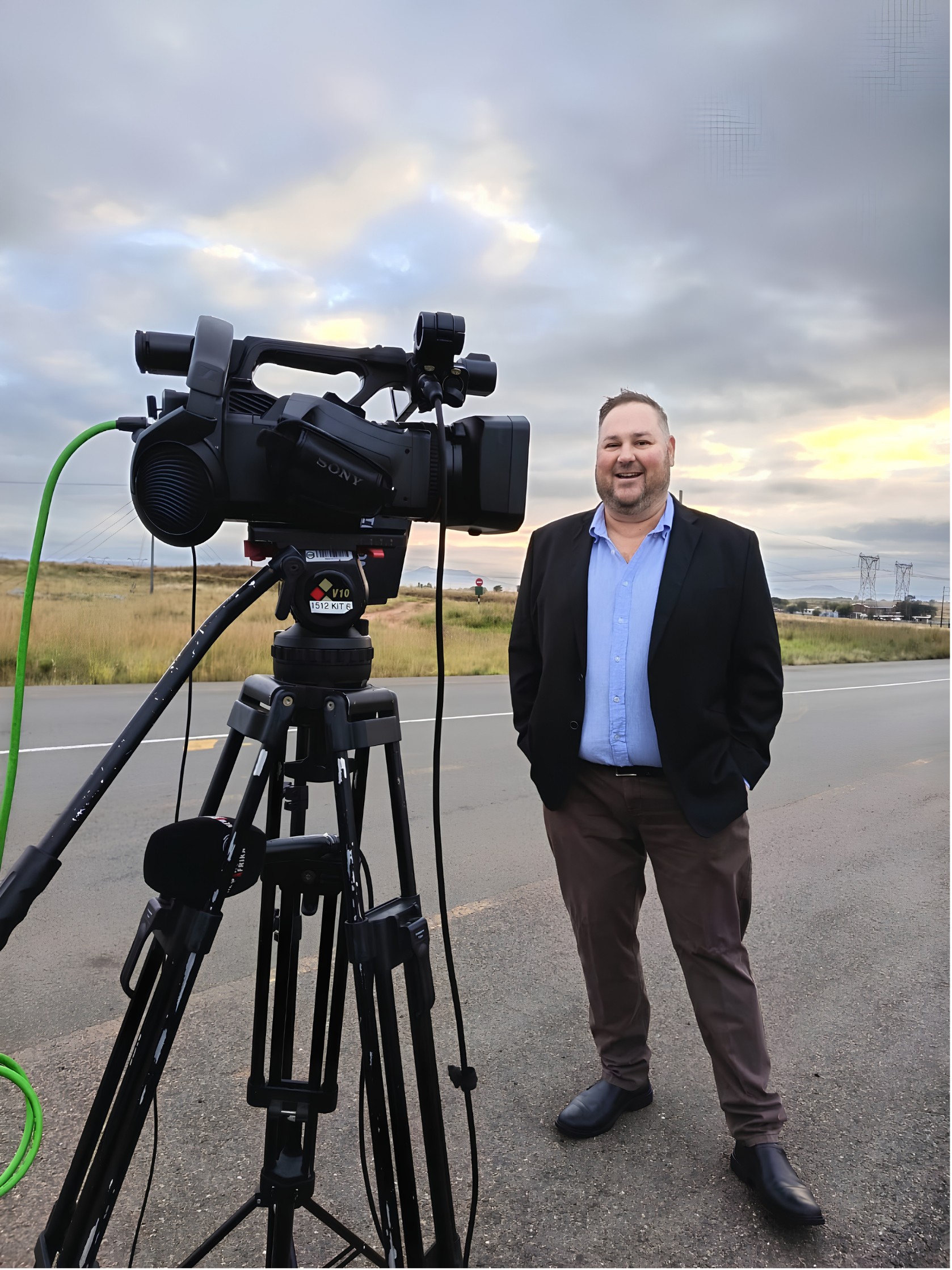 Johan Pieters beside a TV camera on a tripod at the roadside, ready for an interview