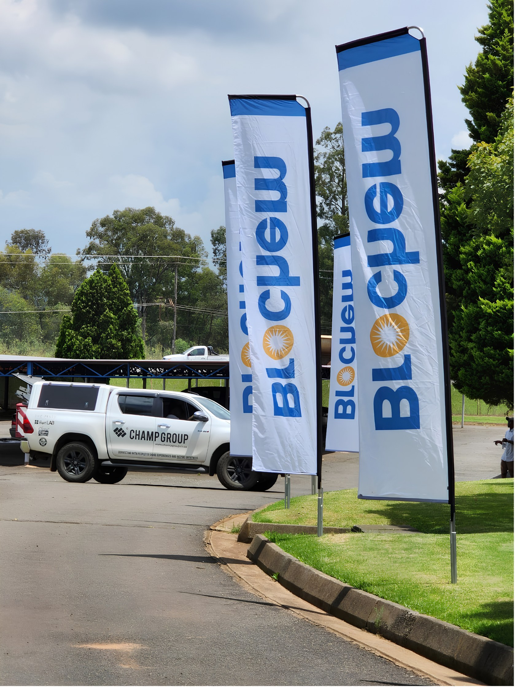 Bloemchem feather flags beside the road, a Champ Group bakkie parked behind